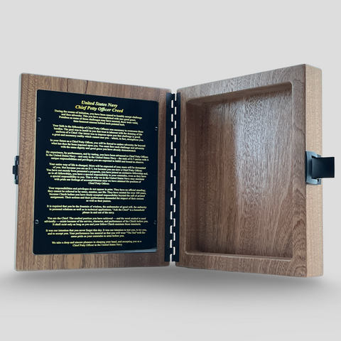 Wooden box with a black plaque inside on a light gray background